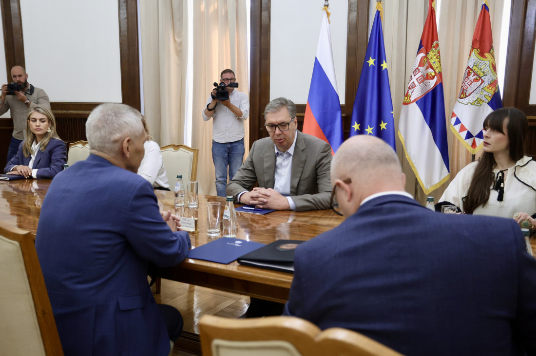 Predsednik Aleksandar Vučić za stolom na sastanku, u pozadini zastave Srbije, Rusije i EU