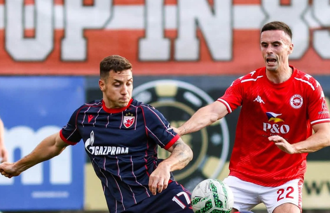 Duel fudbalera Crvene zvezde u tamnom dresu i igrača Larna u crvenom dresu tokom utakmice