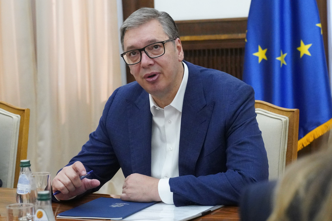 Predsednik Srbije Aleksandar Vučić za stolom tokom sastanka, iza njega zastava Evropske unije