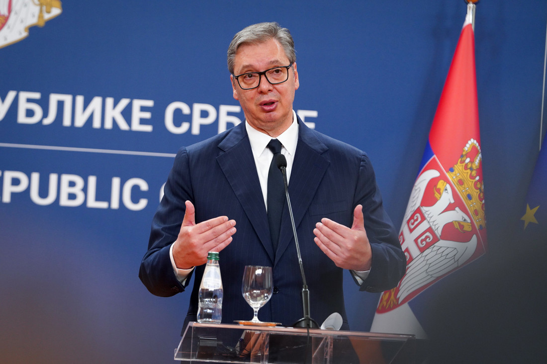 Predsednik Srbije Aleksandar Vučić govori za govornicom pored zastave Srbije