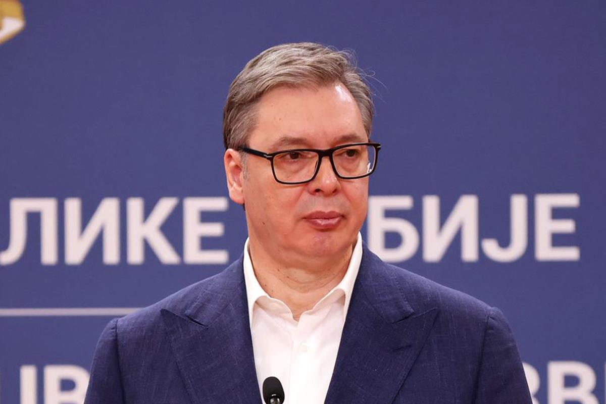 Aleksandar Vučić govori za govornicom ispred plave pozadine sa natpisom Republike Srbije