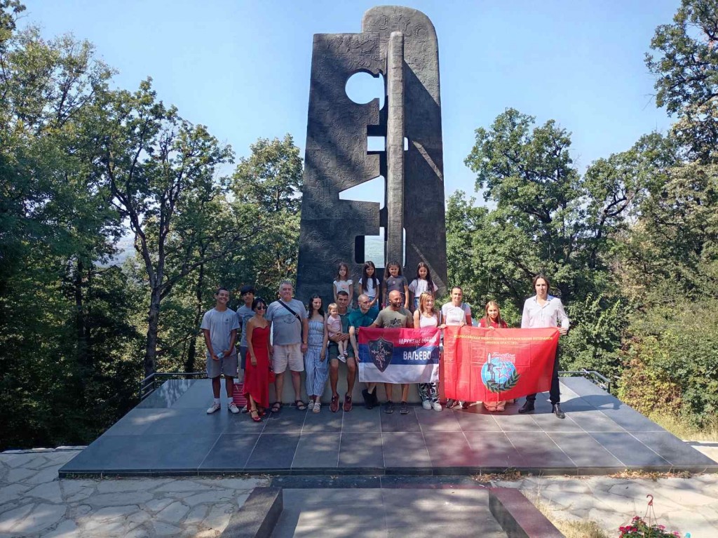Grupa učenika i odraslih sa zastavama Udruženja boraca Valjevo ispred spomenika sovjetskim ratnim veteranima na Avali