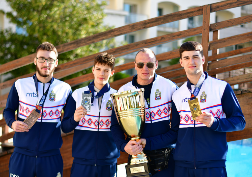 Bokseri reprezentacije Srbije u plavo-belim trenerkama sa peharom i medaljama