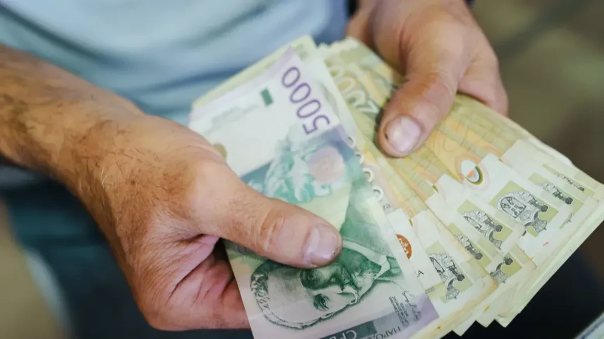 Ruke drže svežanj dinarskih novčanica od 5000, 2000 i 1000 dinara