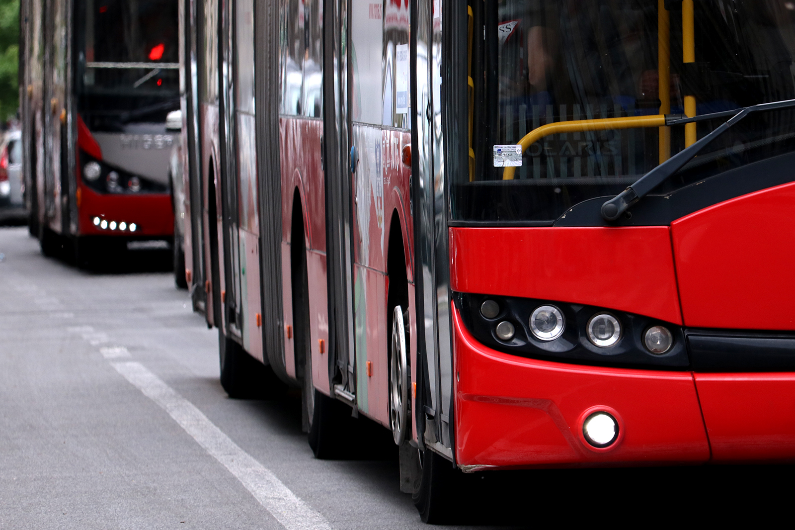 Crveni gradski autobusi u koloni na beogradskoj ulici