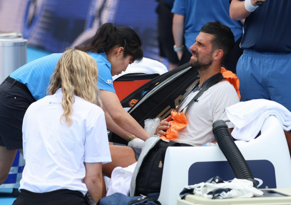 Novak Đoković sedi na klupi vidno iscrpljen dok mu medicinsko osoblje ukazuje pomoć tokom meča