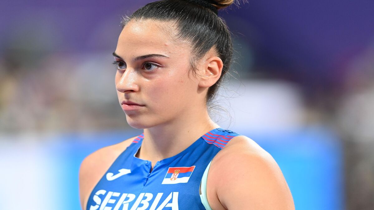 Adriana Vilagoš u plavom dresu sa oznakom SERBIA i srpskom zastavom, portret na stadionu