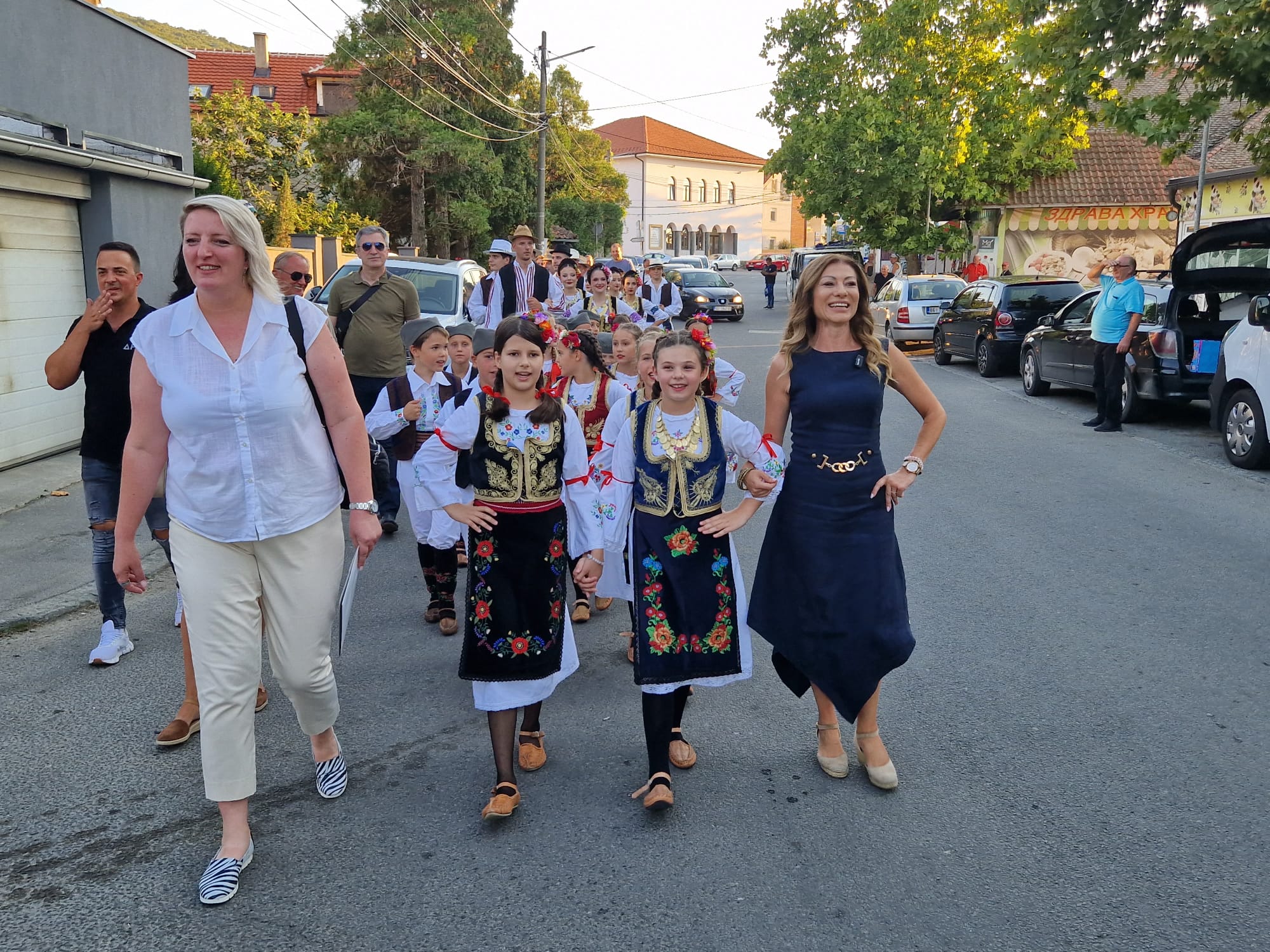 Deca u narodnim nošnjama u pratnji predstavnika opštine prolaze ulicom Belog Potoka