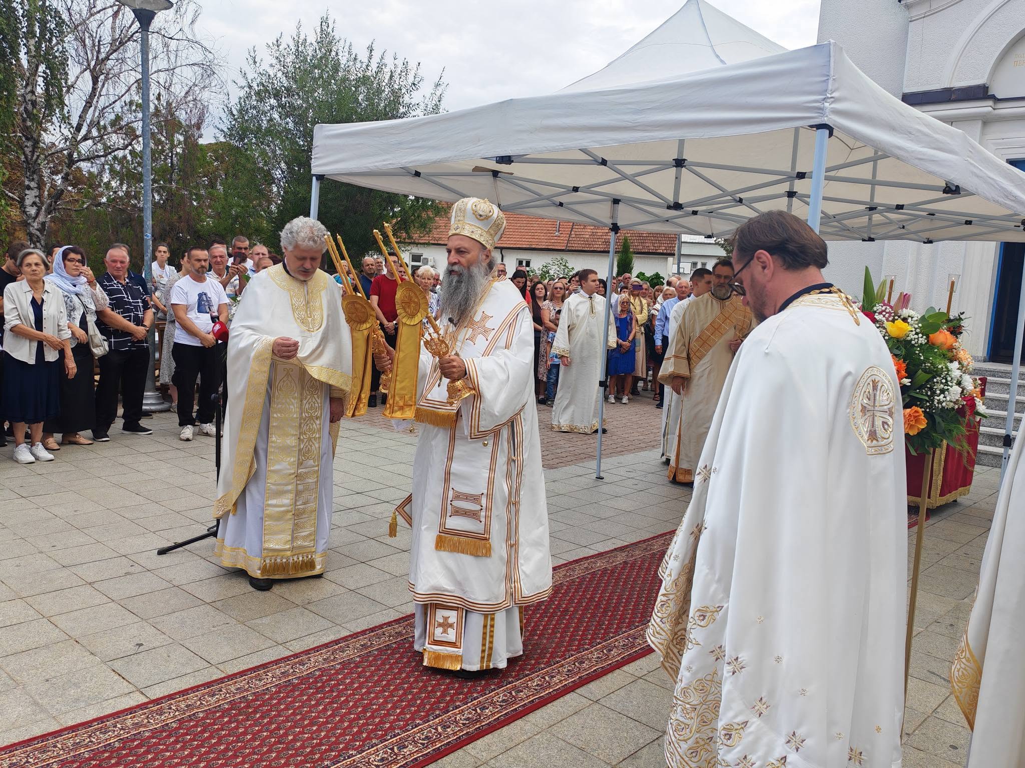 Patrijarh Porfirije u bogoslužbenom odježdu ispred hrama, okružen sveštenstvom i vernicima