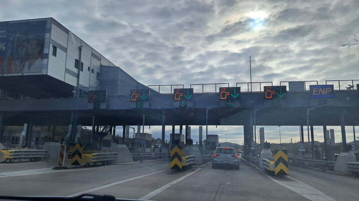 Prilaz naplatnoj stanici na auto-putu, automobil prolazi kroz naplatnu rampu
