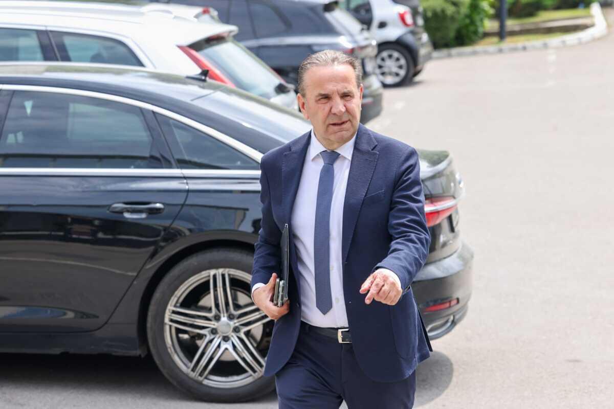 Rasim Ljajić u odelu prolazi pored parkiranih automobila