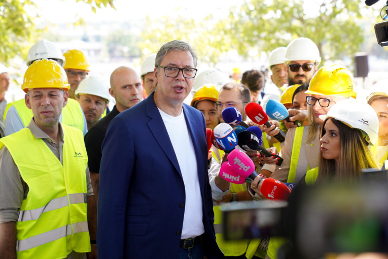 Predsednik Vučić govori novinarima okružen vatrogascima i radnicima u prslucima