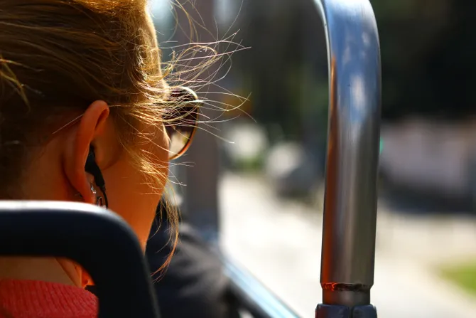 Putnica u autobusu gleda kroz prozor tokom vožnje