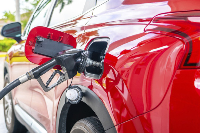 Pištolj za točenje goriva u rezervoaru crvenog automobila na pumpi