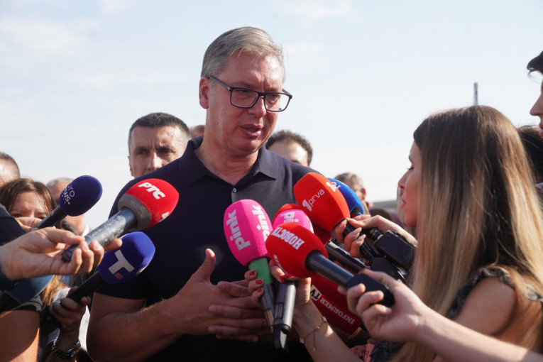 Aleksandar Vučić govori novinarima okružen mikrofonima na otvorenom