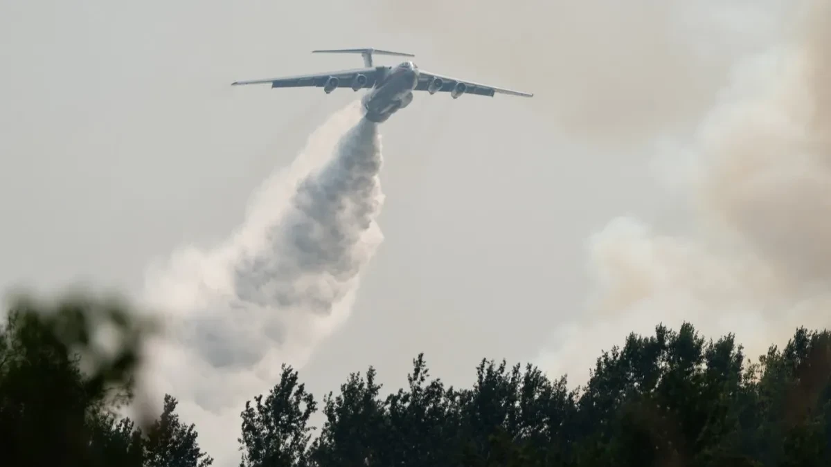 Protivpožarni avion izbacuje veliku količinu vode iznad šume zahvaćene požarom