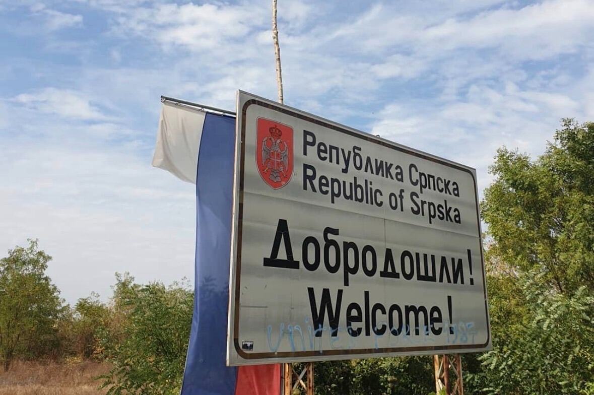 Putna tabla sa natpisom Republika Srpska i Dobrodošli, pored nje istaknuta zastava