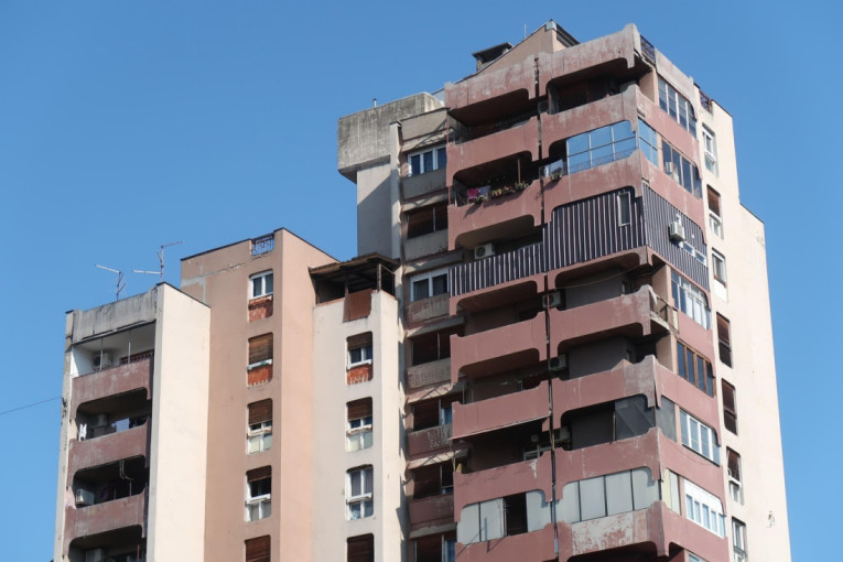 Stambena zgrada sa terasama i klima uređajima na fasadi, snimljena pod vedrim nebom