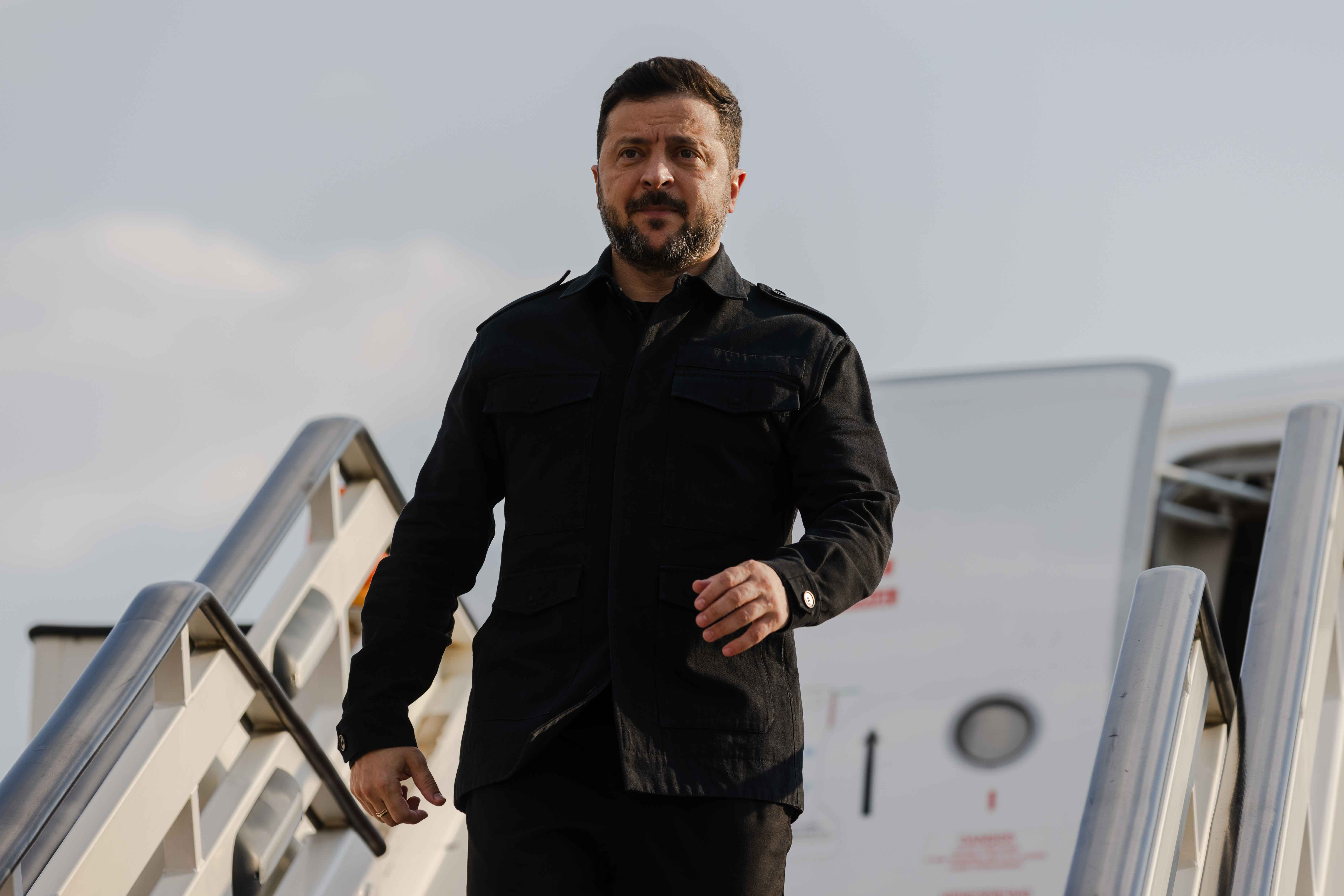 Volodimir Zelenski u crnoj odeći silazi niz avionske stepenice na aerodromu