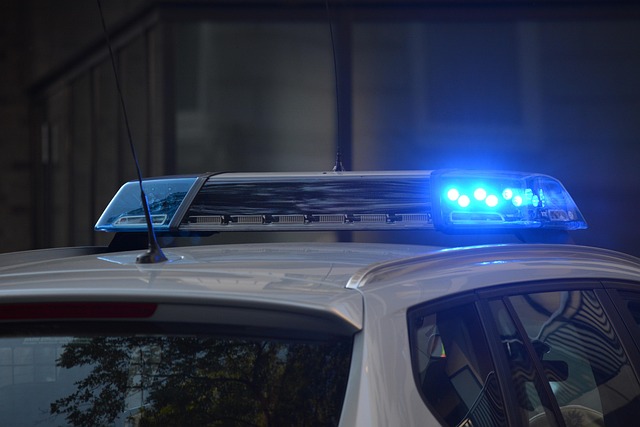 Upaljena plava rotaciona svetla na krovu policijskog vozila u noći
