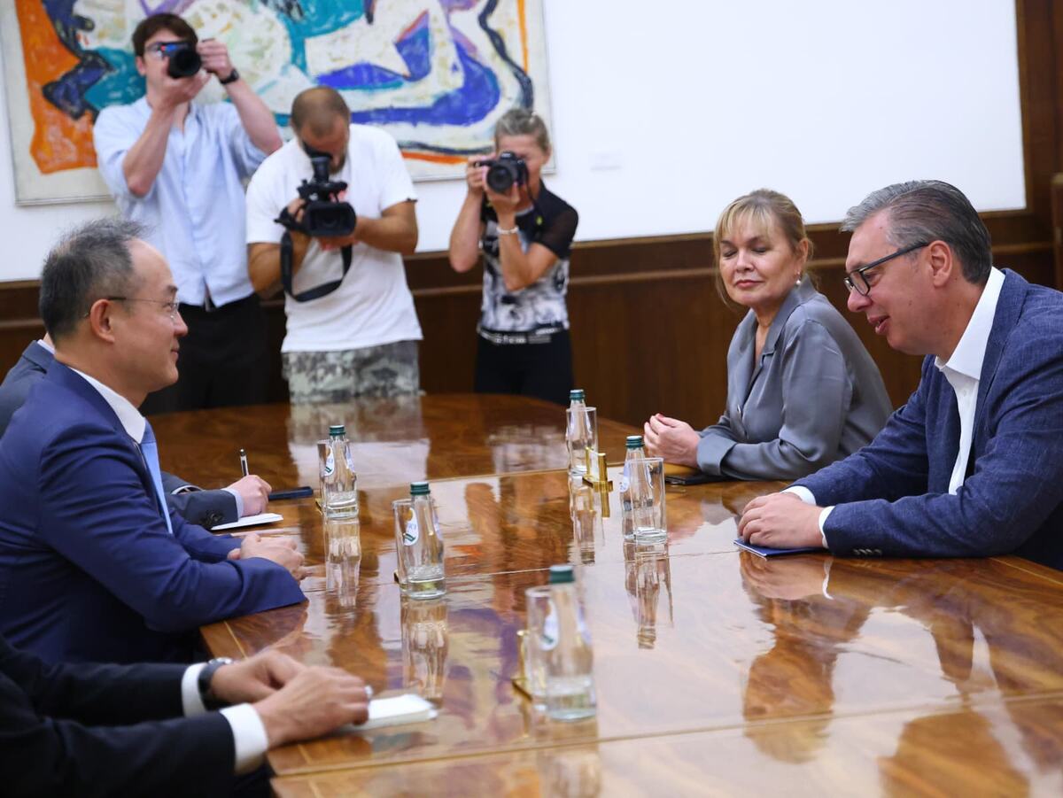 Aleksandar Vučić i kineski ambasador za stolom u sali, u pozadini snimatelji i fotoreporteri
