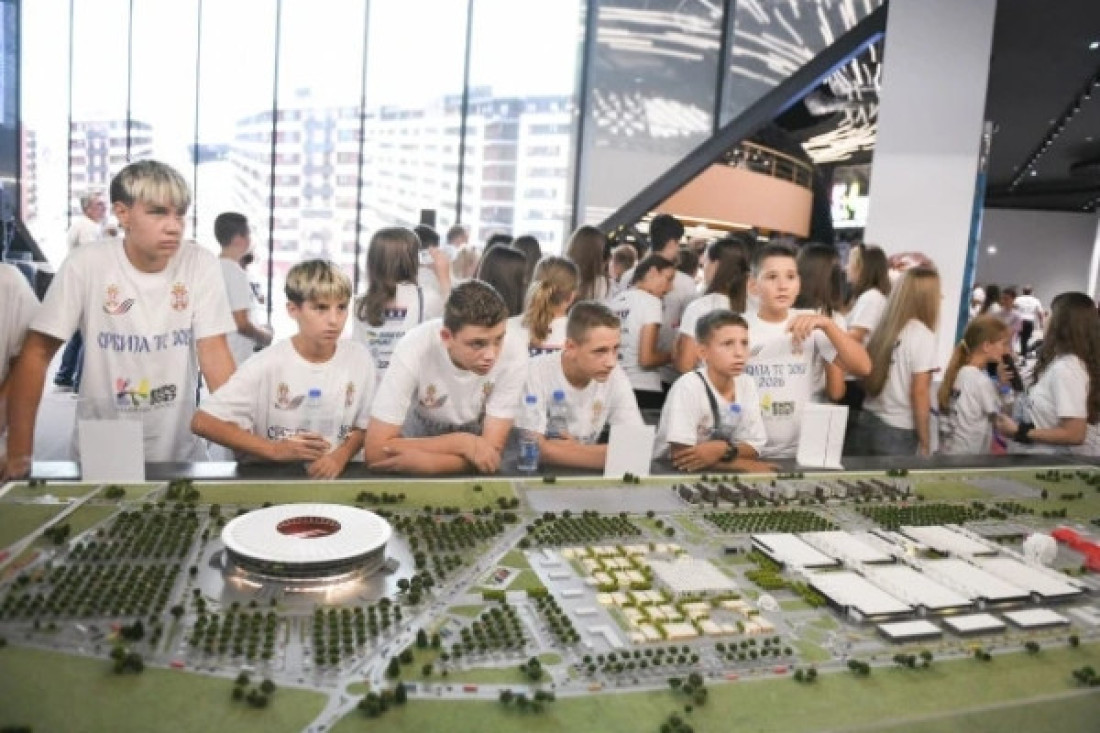 Deca u belim majicama gledaju maketu kompleksa Ekspo 2027 sa stadionom