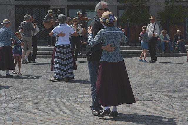 Stariji parovi plešu na gradskom trgu uz muzičare u pozadini