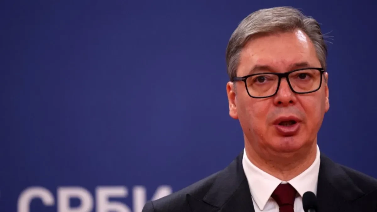 Aleksandar Vučić govori za govornicom ispred plave pozadine