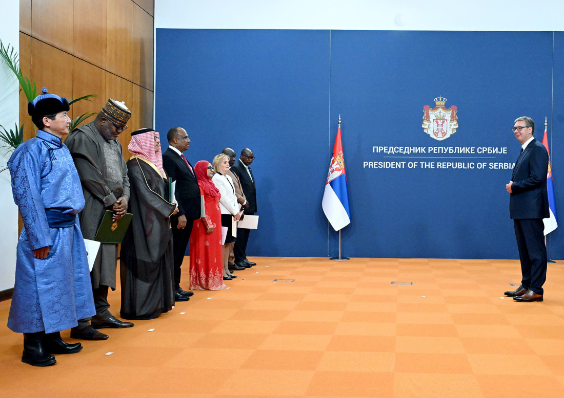 Osam ambasadora u svečanoj odeći stoji naspram Aleksandra Vučića u sali Palate Srbija sa zastavom i grbom Srbije