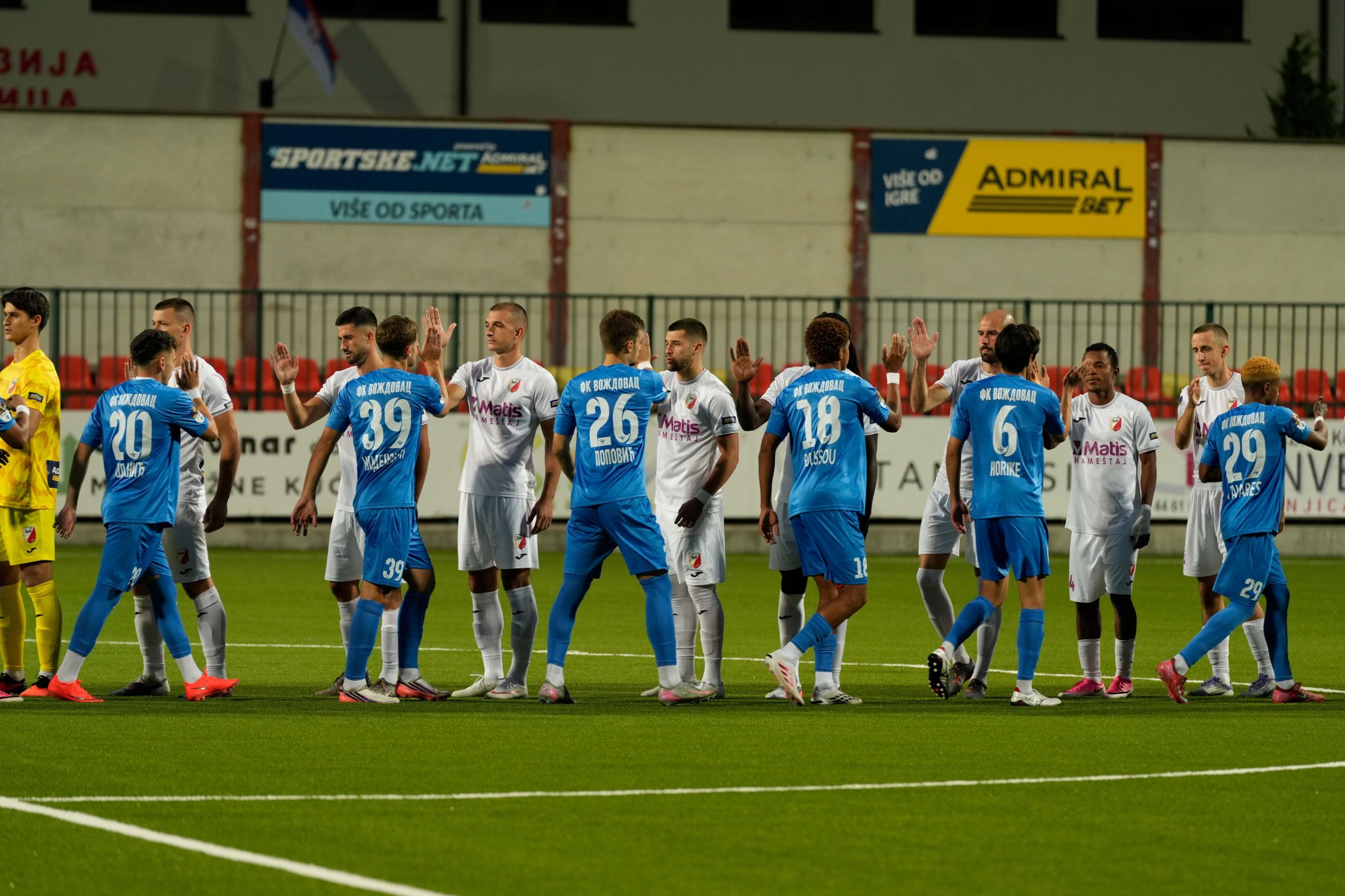 Fudbaleri Voždovca u plavim i Javora u belim dresovima pozdravljaju se pred početak utakmice