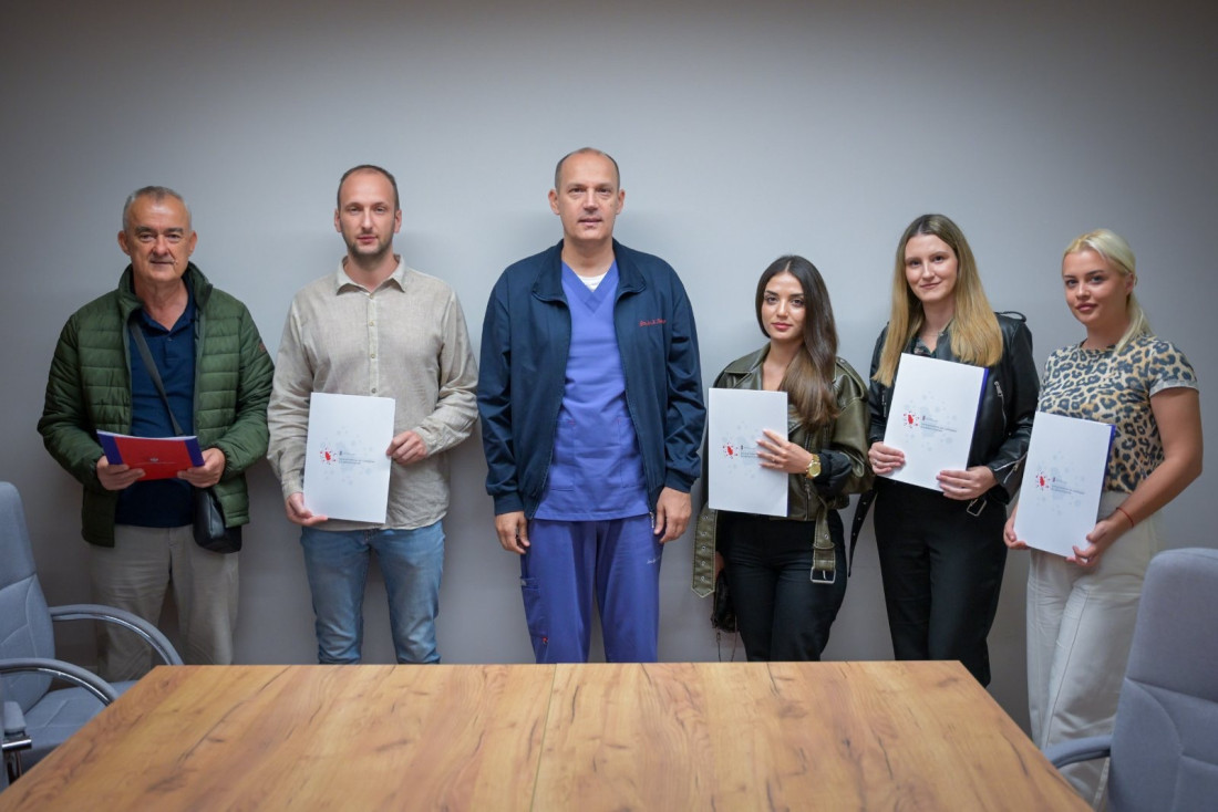Grupa zdravstvenih radnika sa ministrom zdravlja, u ruci drže fascikle sa dokumentima