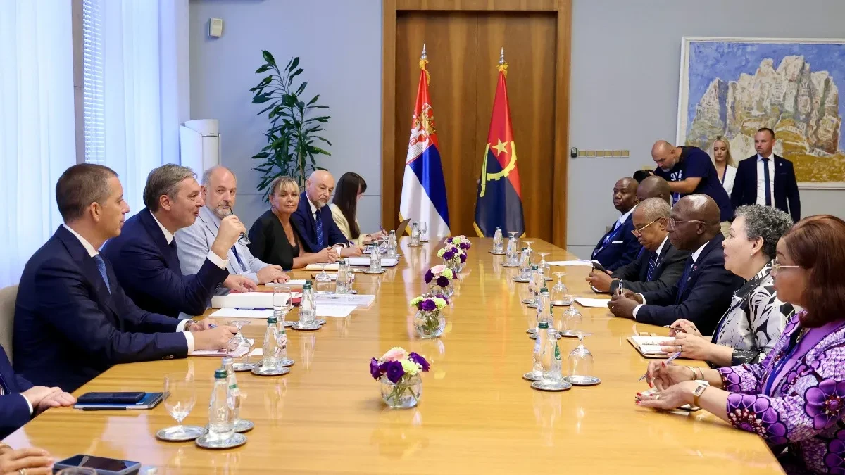 Predsednik Vučić i saradnici sede za dugačkim stolom naspram delegacije Angole u Palati Srbija, u pozadini zastave Srbije i Angole