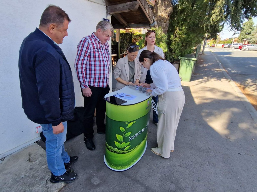 Predstavnici grada i opštine sa meštanima pregledaju filter za ložište na štandu na ulici u Zucu