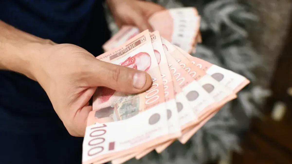 Ruke drže lepezu novčanica od 1.000 dinara