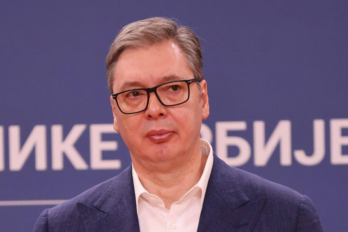 Aleksandar Vučić u tamnom sakou ispred plave pozadine