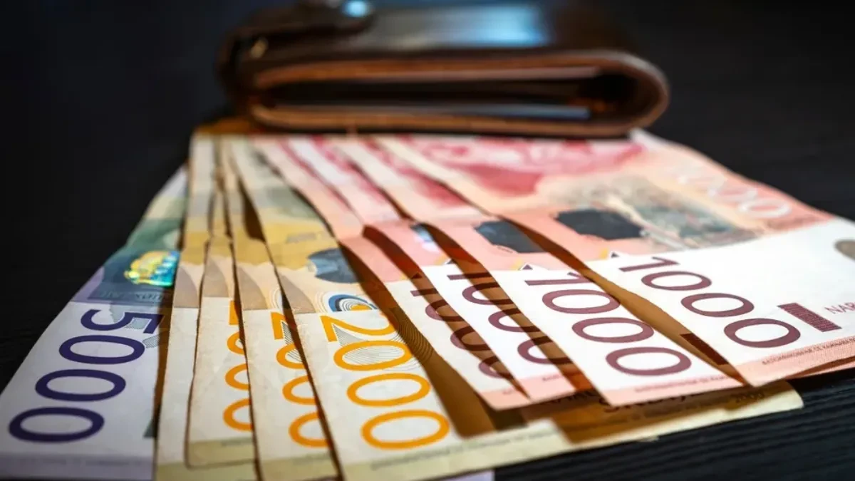 Novčanice dinara raširene ispred kožnog novčanika