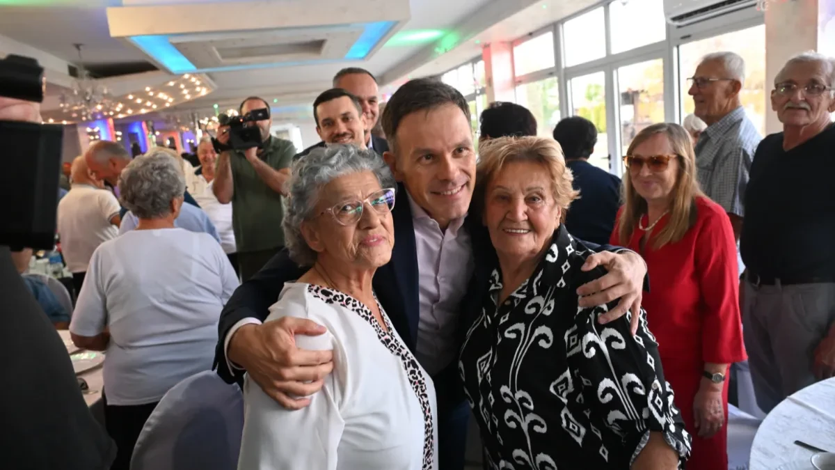 Siniša Mali grli dve starije žene na skupu penzionera u sali restorana