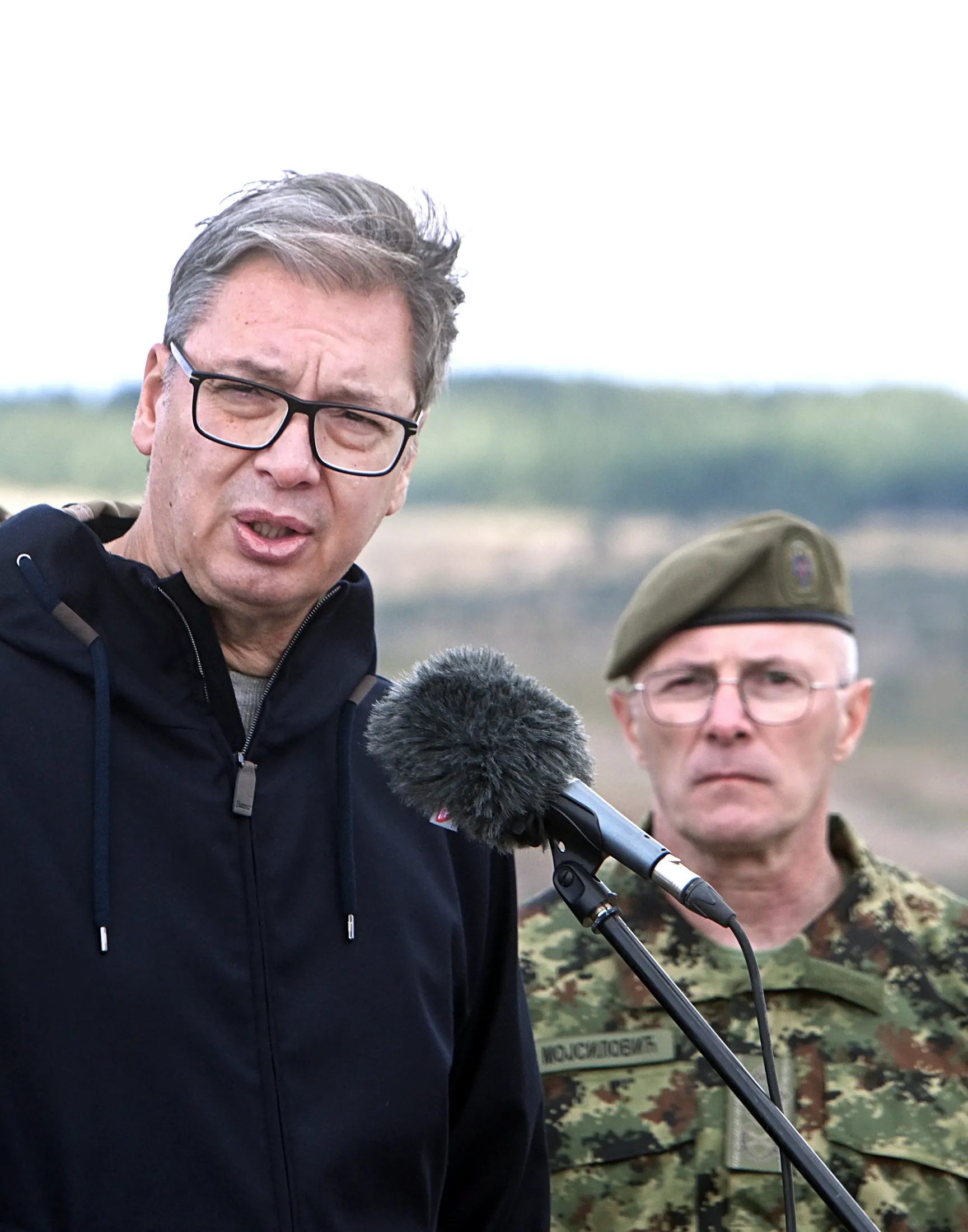 Aleksandar Vučić govori za mikrofon na poligonu, iza njega stoji oficir Vojske Srbije
