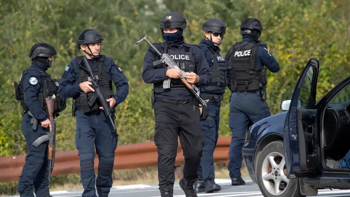 Naoružani pripadnici kosovske policije pored puta i parkiranog automobila