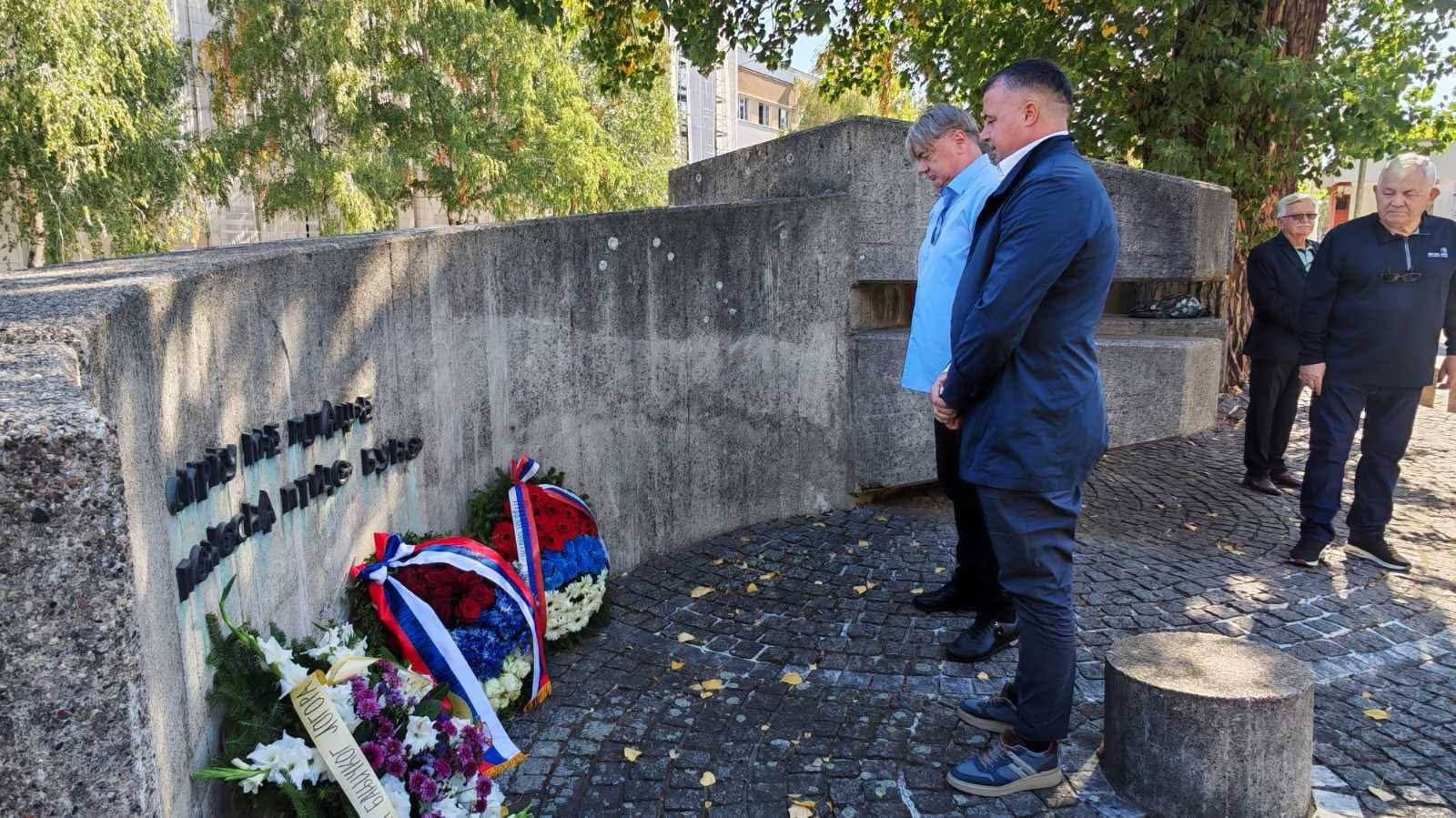Odavanje počasti kod spomenika žrtvama Banjičkog logora, ispred zida položeni venci u bojama trobojke
