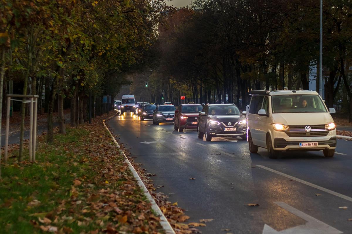 Kolona automobila na gradskoj ulici u sumrak