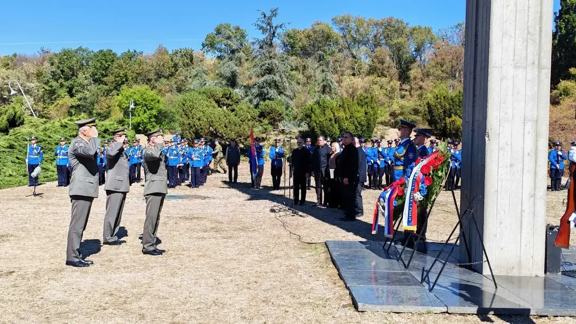 Oficiri Vojske Srbije odaju počast ispred spomenika sa položenim vencima, u pozadini pripadnici Garde