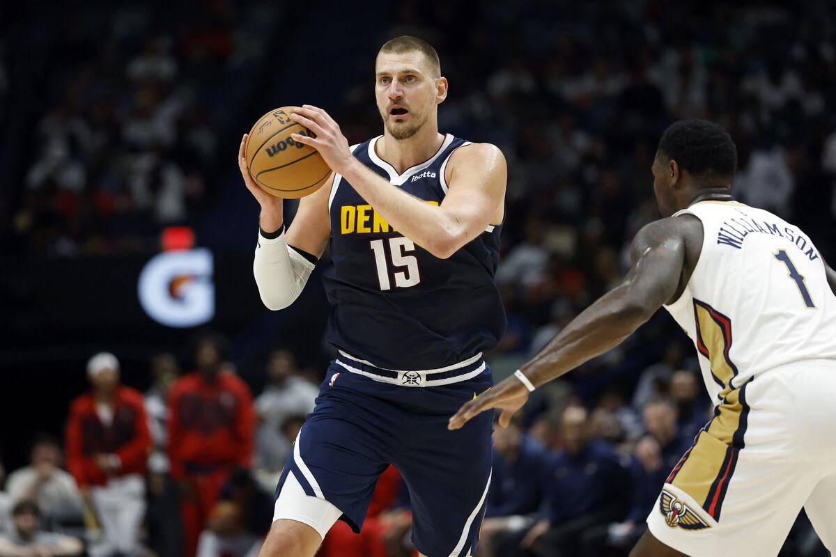 Nikola Jokić u dresu Denvera sa loptom u rukama, ispred njega Zajon Vilijamson
