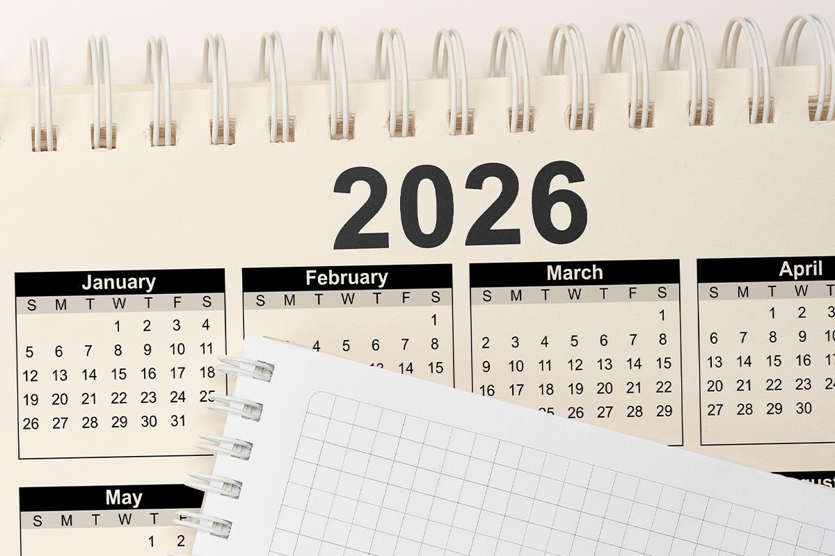 Stoni kalendar sa spiralom za 2026. godinu i otvorena sveska na kockice