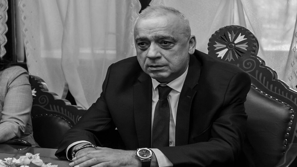Crno-bela fotografija Stevana Bakića u odelu i kravati dok sedi za stolom