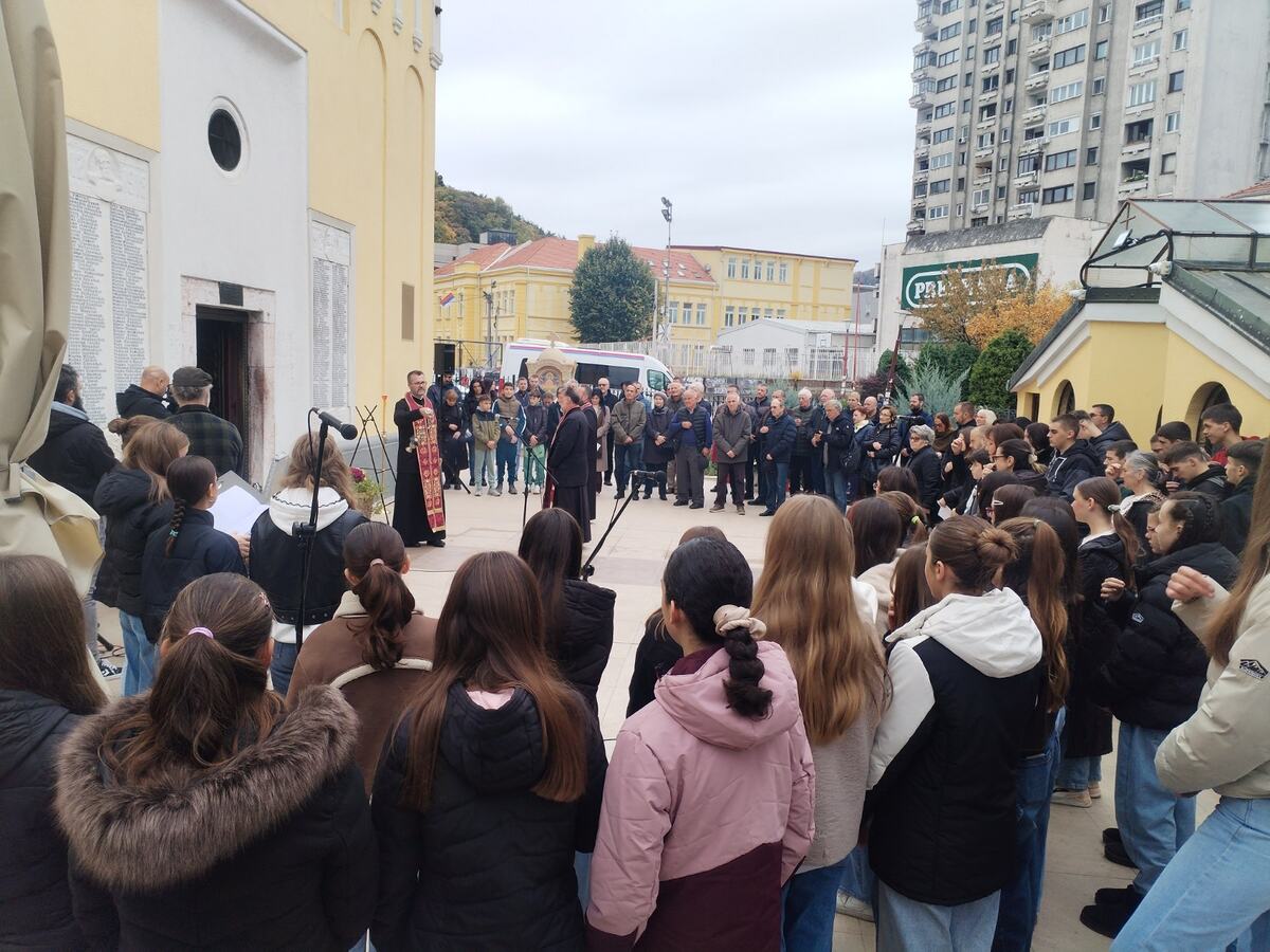 Sveštenik služi pomen u porti crkve pred okupljenim građanima i učenicima