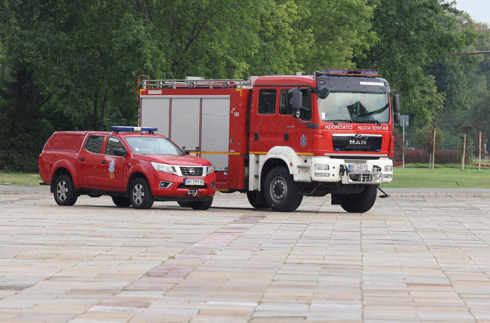 Vatrogasno vozilo i terenac vatrogasne službe parkirani na popločanom platou
